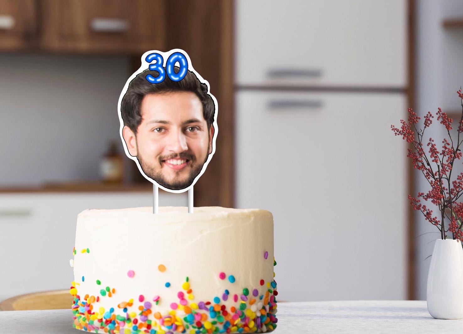A cake topper featuring a head cut out from a photo, with the number 30 placed on top, adding a personalized touch to your celebration.