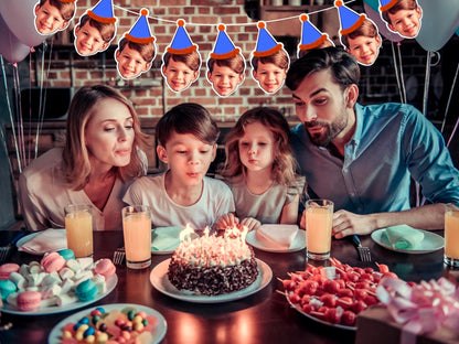 Family birthday celebration with custom face banner featuring a child in blue party hat with orange trim. Banner hangs above cake as family blows out candles. Perfect personalised party decoration.