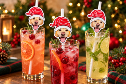 Text-free close-up of pet christmas photographic head toppers on white paper straws in tall glasses.